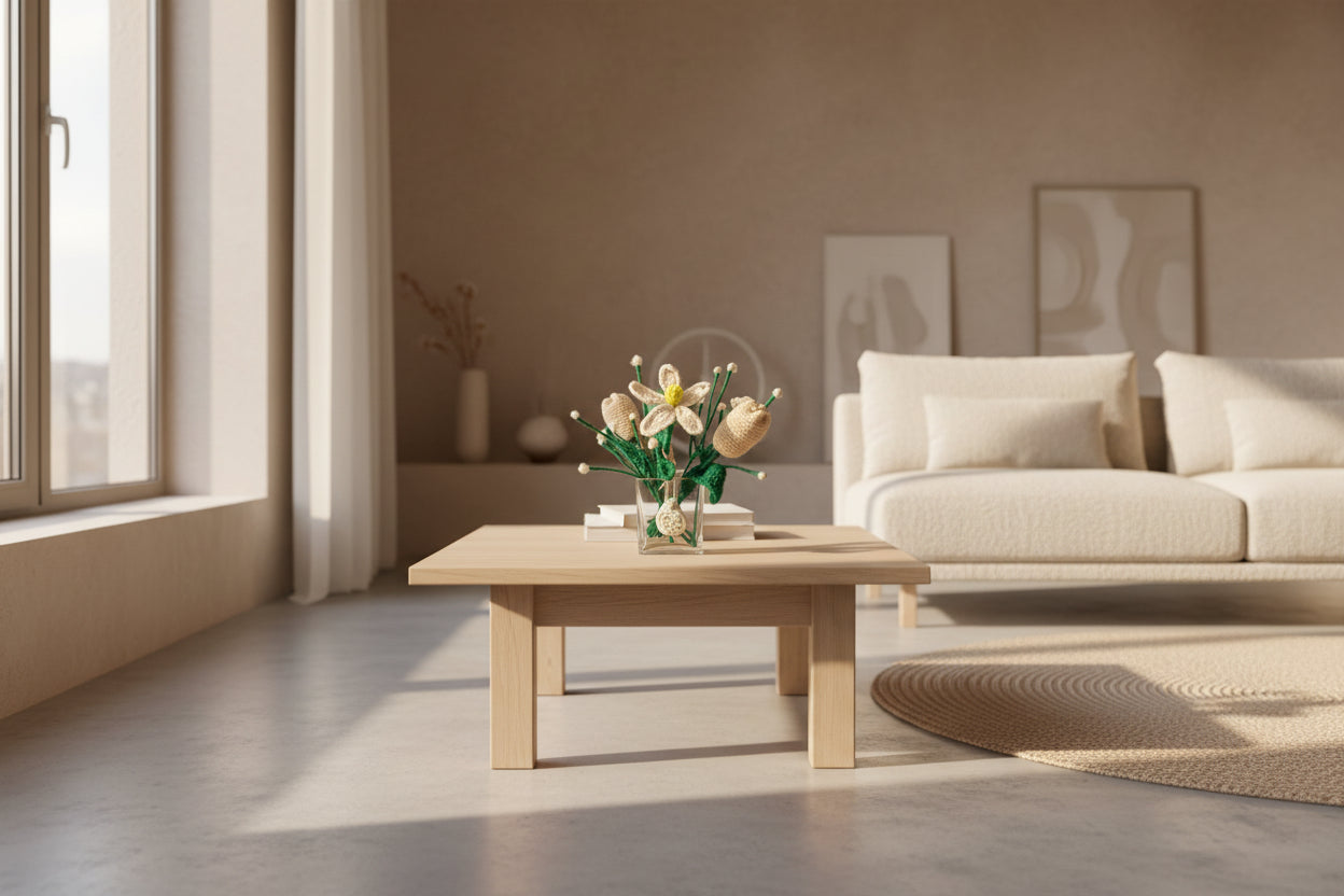 Knitted flowers in a clear glass bottle on a white surface