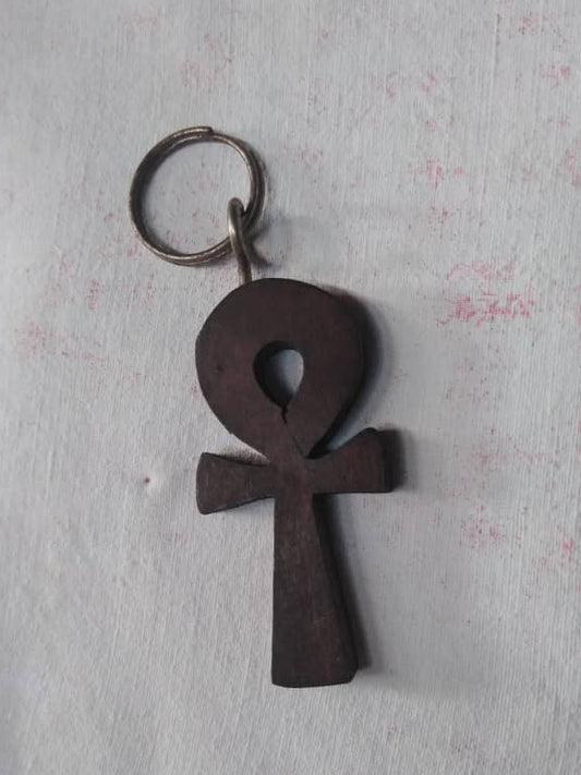 Wooden ankh keychain on a textured white background
