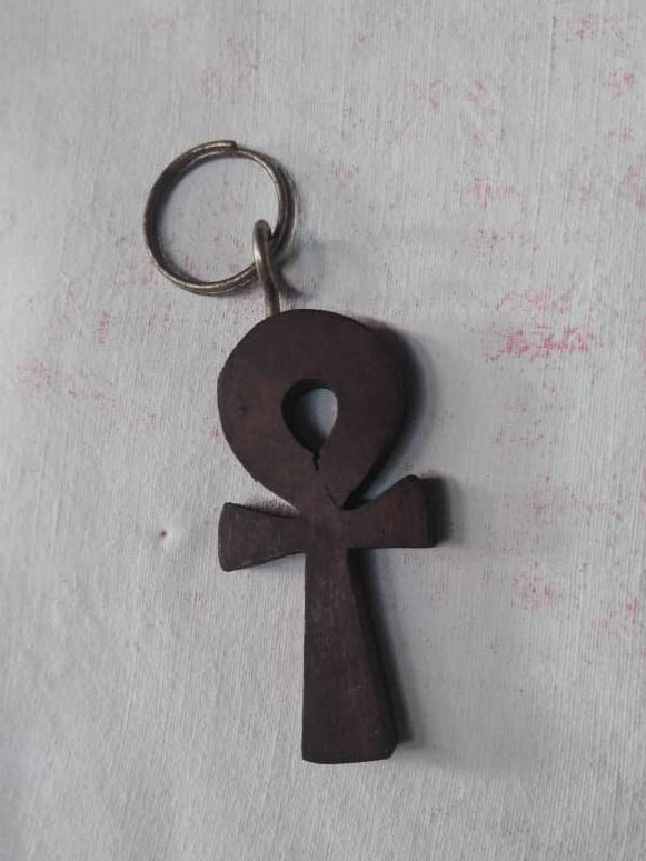 Wooden ankh keychain on a textured white background